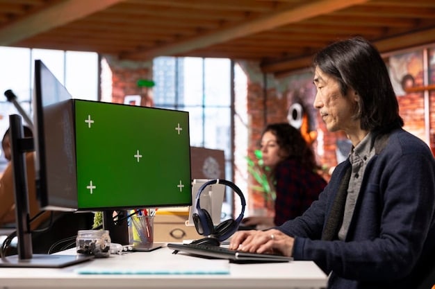 A high-resolution screenshot of the development team at Santa Monica Studio working together in a brightly lit office. Various computer screens displaying game development software are visible.