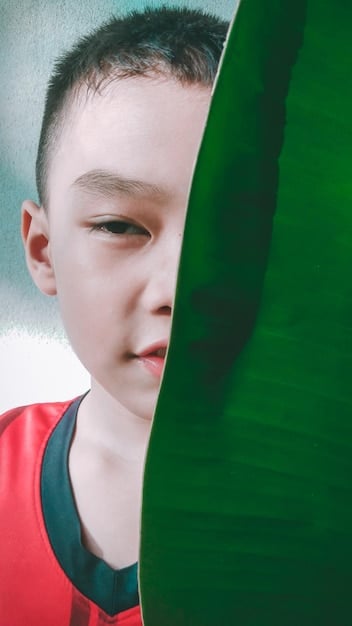 A split image showing a child's face, one side lit brightly and enthusiastically looking at a game, the other side shadowed and concerned, symbolizing the contrasting emotional effects of in-game purchases.